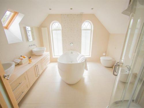a large bathroom with two sinks and a large tub at Queen Bee & B in Merthyr Tydfil