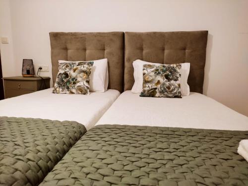 a bedroom with two beds with pillows on them at Pitões NatureHouse in Pitões das Júnias