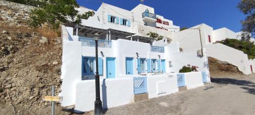 a white building with blue windows and a street light at ASVESTOTI MESONETTES BLUE LIGHT ΣΙΕΛ ΜΕΖΟΝΕΤΕs in Pera Gyalos