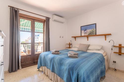 ネルハにあるCapistrano Playaのベッドルーム1室(青い毛布付きのベッド1台付)