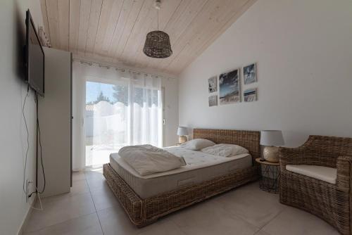 Un dormitorio con una cama y una ventana grande. en La désirée, en Noirmoutier-en-l'Île