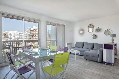 un salon avec une table, des chaises et un canapé dans l'établissement Appartement pour 4 avec vue sur la marina, à Pornichet
