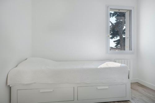 - un lit blanc dans une chambre blanche avec un miroir dans l'établissement Appartement pour 4 avec vue sur la marina, à Pornichet