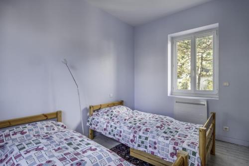 deux lits dans une chambre avec une fenêtre dans l'établissement Villa « Les Libellules » pour 8 personnes, à La Baule