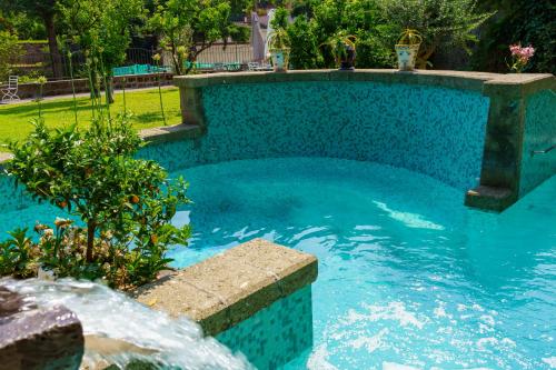 a swimming pool with a fountain in a yard at Villa Manning Relais in Sorrento