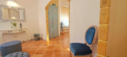 a hallway with a blue chair and a blue door at Sa Branda Costa Country Alghero in Santa Maria la Palma