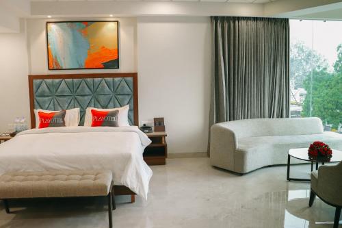 a bedroom with a large bed and a couch at Playotel Premier Guna in Guna