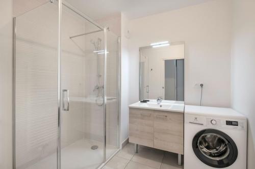 La salle de bains blanche est pourvue d'une douche et d'un lave-linge. dans l'établissement Bel appartement vue mer pour 8, à Pléneuf-Val-André