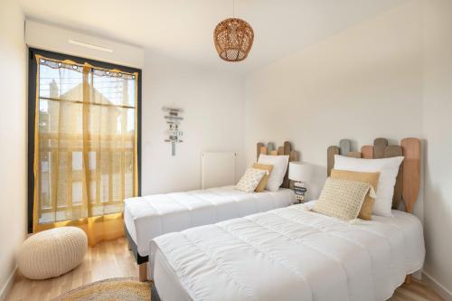 une chambre avec deux lits et une fenêtre dans l'établissement Bel appartement vue mer pour 8, à Pléneuf-Val-André