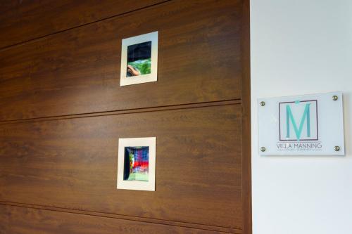 a group of pictures hanging on a wooden wall at Villa Manning Relais in Sorrento