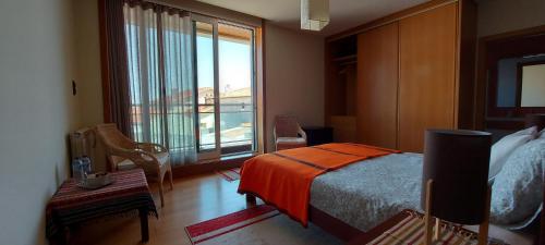 a bedroom with a bed and a large window at Casa do Mar in Costa Nova