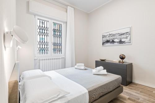 biała sypialnia z łóżkiem i oknem w obiekcie Maragliano Cozy Flat with Balcony we Florencji