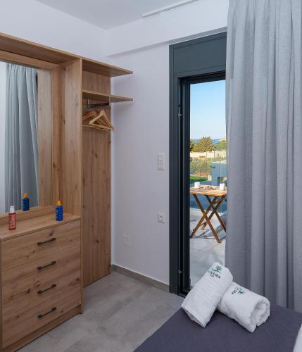 a bedroom with a bed and a view of a table at Olive and Sea Villas in Agia Pelagia