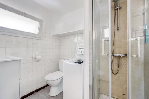 a white bathroom with a toilet and a shower at Séjour détente à Bretignolles-sur-Mer pour 5 personnes in Brétignolles-sur-Mer