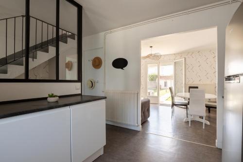 une cuisine avec des placards blancs et une salle à manger dans l'établissement Des vacances en bord de mer pour 10 personnes, à Château-dʼOlonne