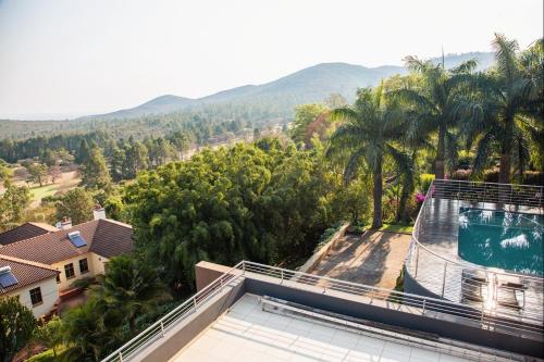 a villa with a swimming pool and palm trees at Schimper View Boutique Guest House in Louis Trichardt