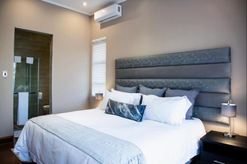 a bedroom with a large bed with a large headboard at Schimper View Boutique Guest House in Louis Trichardt