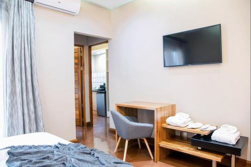 a bedroom with a bed and a desk and a television at Schimper View Boutique Guest House in Louis Trichardt