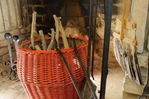 a basket full of utensils sitting next to a fireplace at Villa Mery, sui colli della riviera di Rimini in Mondaino