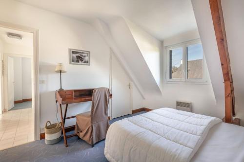 a white bedroom with a bed and a desk at Charmante maison pour 11 personnes à Sarzeau in Sarzeau