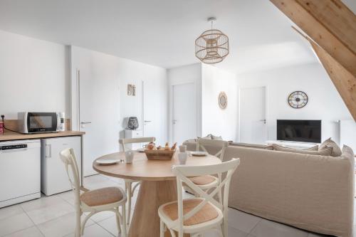 a living room with a table and a couch at Charmant appartement pour 4, remblai de Pléneuf in Pléneuf-Val-André