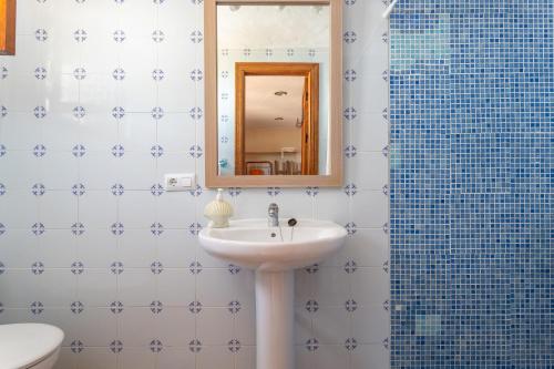 a bathroom with a sink and a mirror and a shower at Fuente luz cottage in Frigiliana