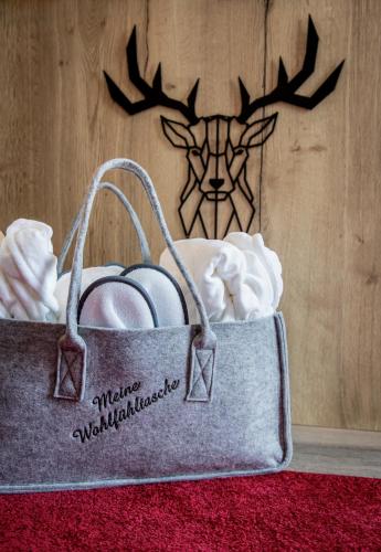 a gray bag with wedding rings in front of a wall at Arcus Hotel München Messe in Feldkirchen
