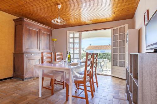 une salle à manger avec une table et des chaises dans une cuisine dans l'établissement Agréable maison pour 6 à Saint-Hilaire-de-Riez, à Saint-Hilaire-de-Riez