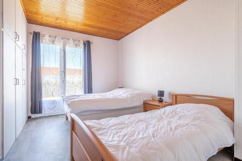 une chambre avec deux lits et une fenêtre dans l'établissement Agréable maison pour 6 à Saint-Hilaire-de-Riez, à Saint-Hilaire-de-Riez