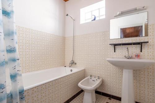 une salle de bain avec un lavabo, une baignoire et des toilettes dans l'établissement Agréable maison pour 6 à Saint-Hilaire-de-Riez, à Saint-Hilaire-de-Riez