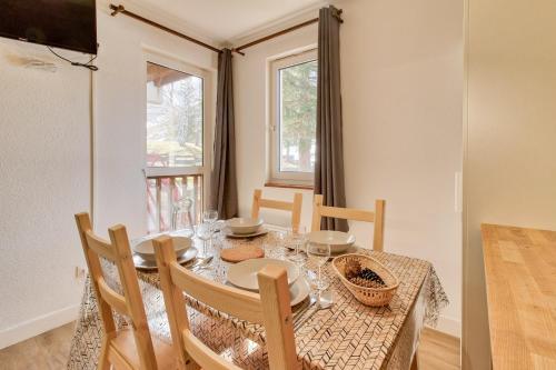 a dining room with a table and chairs and a window at Accès direct aux pistes - appartement pour 4 in Génos