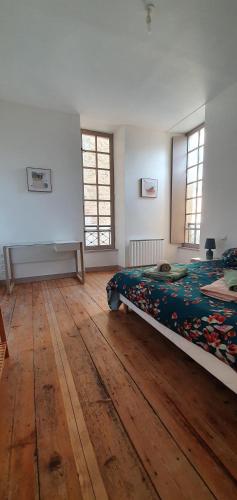 une chambre avec un lit et un parquet dans l'établissement Centre ville historique 3 pieces duplex, à Bergerac