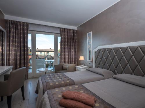 a hotel room with two beds and a balcony at Parc Hotel Gritti in Bardolino