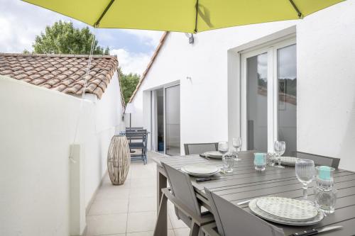 - une salle à manger avec une table et un parasol dans l'établissement Appartement à 300m de la Plage de Ste Marie S/Mer, à Pornic