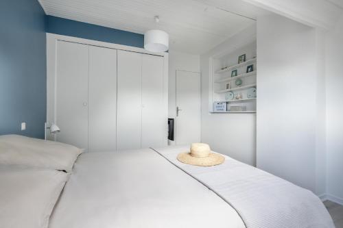 - une chambre avec un lit blanc et un chapeau dans l'établissement Appartement à 300m de la Plage de Ste Marie S/Mer, à Pornic