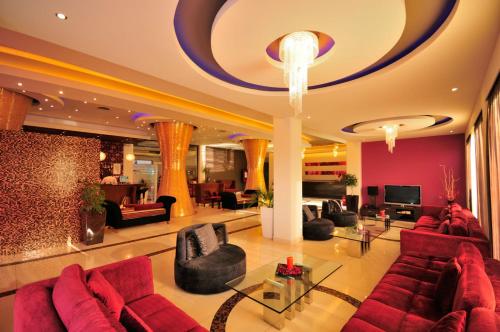a large living room with red furniture and a chandelier at Afandou Bay Resort Suites in Afantou
