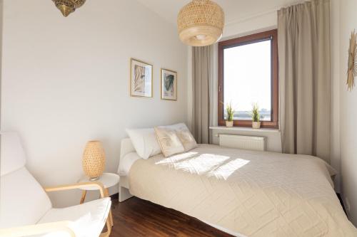 ワルシャワにあるMokotów Premium Apartment with Terraceの白いベッドルーム(ベッド1台、椅子付)