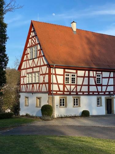 una gran casa blanca con techo rojo en Schlosshotel Götzenburg, en Jagsthausen