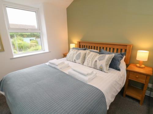 - une chambre avec un lit avec deux oreillers et une fenêtre dans l'établissement Honey Pot Cottage, à Lancaster