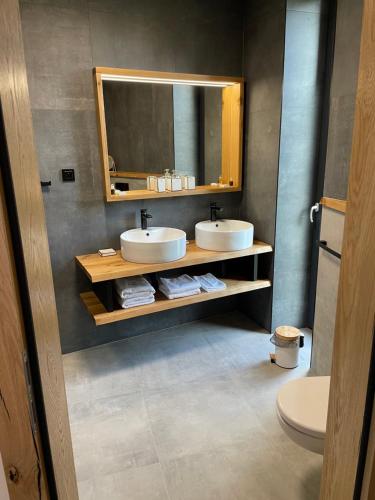 a bathroom with two sinks and a mirror at Panorama Kořenec in Kořenec
