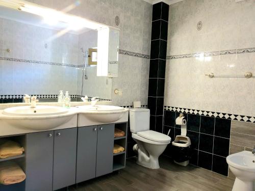 ein Badezimmer mit zwei Waschbecken und einer Toilette und einem Spiegel in der Unterkunft Pensiunea Confort in Suceava