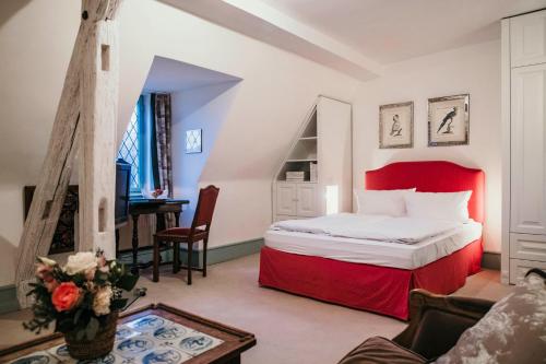 ein Hotelzimmer mit einem Bett und einem Schreibtisch in der Unterkunft Schlosshotel Götzenburg in Jagsthausen