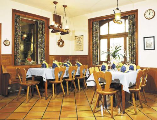 ein Esszimmer mit Tischen, Stühlen und einer Uhr in der Unterkunft Gasthaus Merkel Hotel in Bad Berneck im Fichtelgebirge