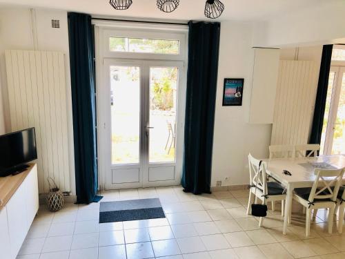 a living room with a dining room table and a door at Maison avec terrasse à 50 m de la mer in Pornic