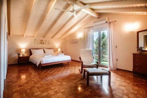 a bedroom with a bed and a chair and a window at Villa Butterfly - Heated Pool, Jacuzzi, Sauna, Gym in Corfu Town
