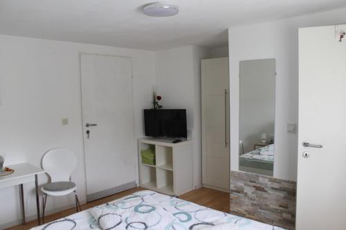 a white room with a bed and a television at Zimmer Steger in Gnas