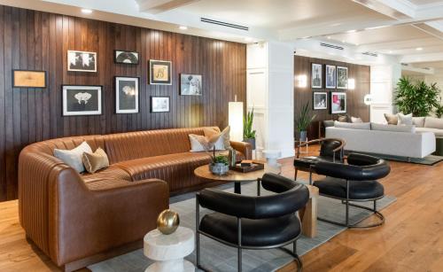 a living room with a brown couch and chairs at Hutton Hotel in Nashville