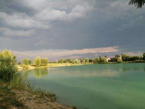 a large body of water with a cloudy sky at Big Garden House in Dunajská Streda
