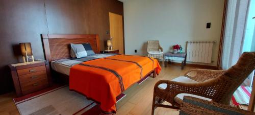 a bedroom with a bed with an orange blanket at Casa do Mar in Costa Nova