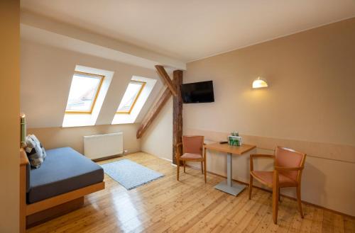 a bedroom with a bed and a table with chairs at JUFA Hotel Judenburg - Self Check-In in Judenburg